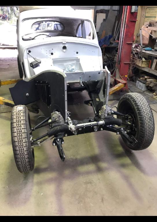 A good shot showing the bumper carriers, steering rack, lever arm shock absorbers, brake booster cover on rhs behind wheel, new Michelin X tires, rebuilt wiper motor and cable. Exterior under body has already been primed with anti rust primer and black underbody sealer.